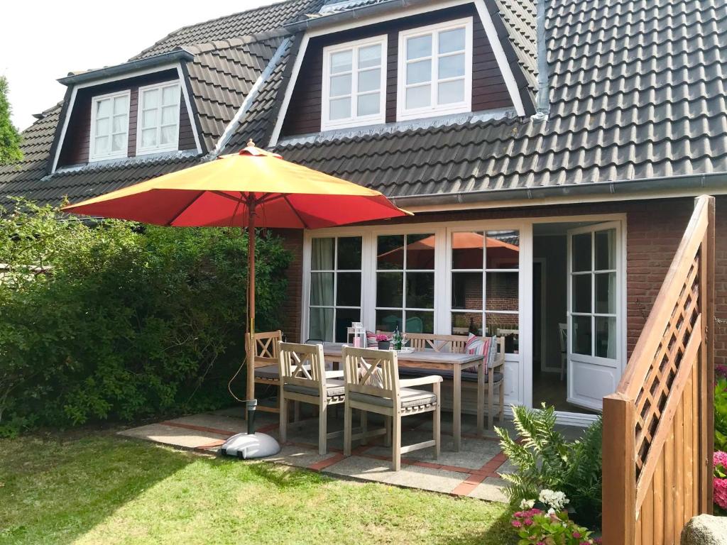 a patio with a table and an umbrella at Deichblick in Nieblum in Nieblum