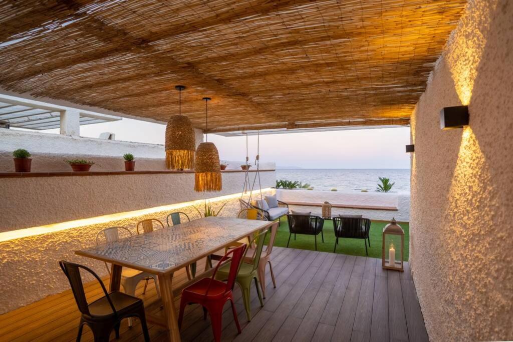 ein Esszimmer mit einem Tisch und Stühlen auf einer Terrasse in der Unterkunft Sea Level, Apto sofisticado en primera linea playa in Aguadulce