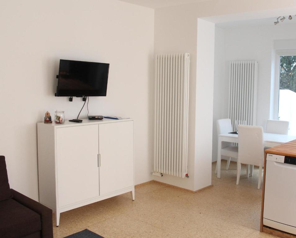 un soggiorno con TV e armadietto bianco di Haus Roy - Ferienwohnung Erdgeschoß a Zülpich