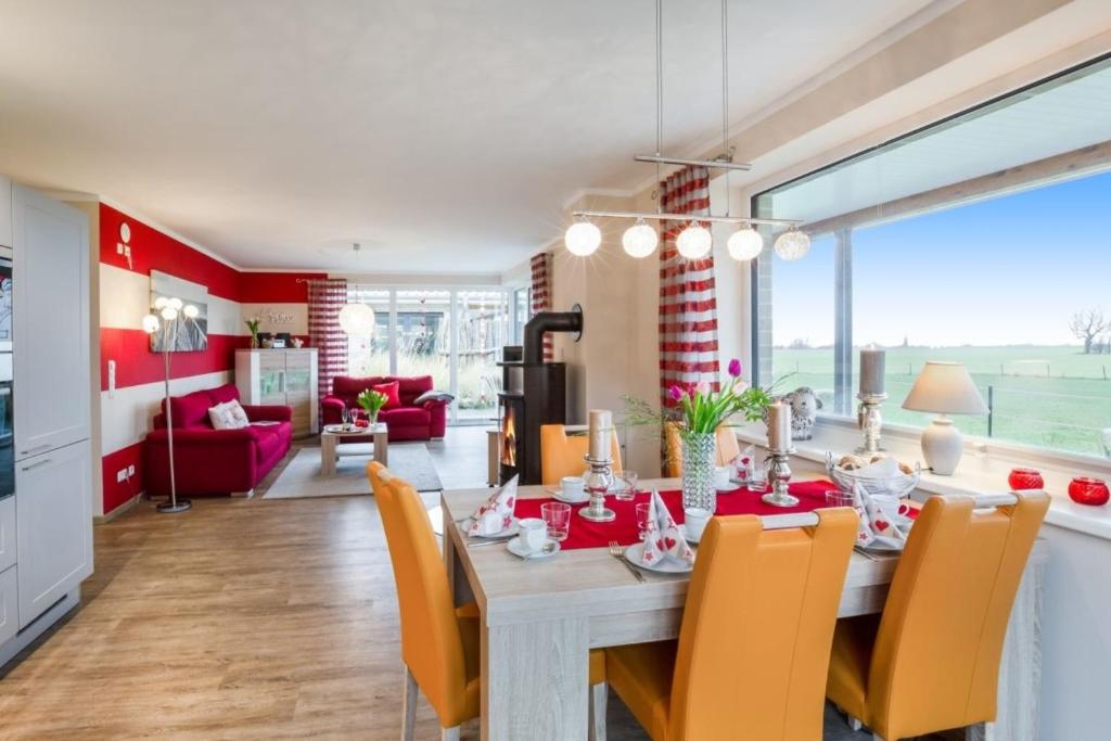 comedor y sala de estar con mesa y sillas en Wellness - Bungalow Strandgut en Klausdorf
