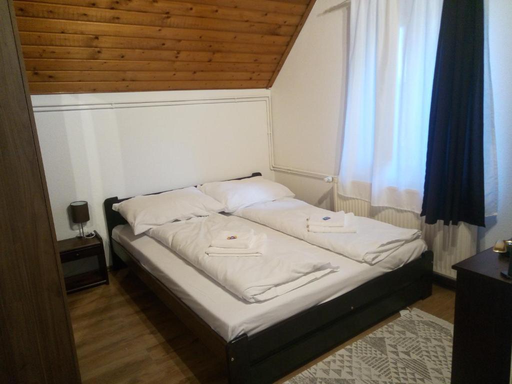 - un petit lit dans une chambre avec fenêtre dans l'établissement Krisztina Apartman 2-3, à Szigethalom