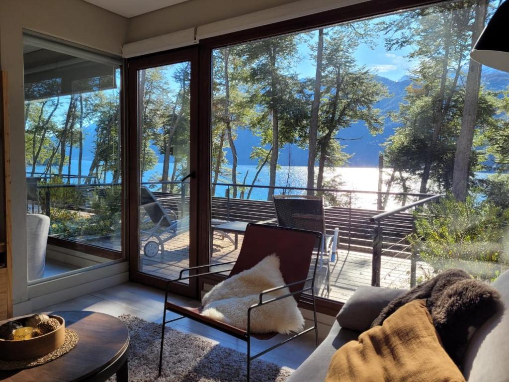 sala de estar con vistas al agua en Departamento con vista al lago y piscina climatizada en Villa La Angostura