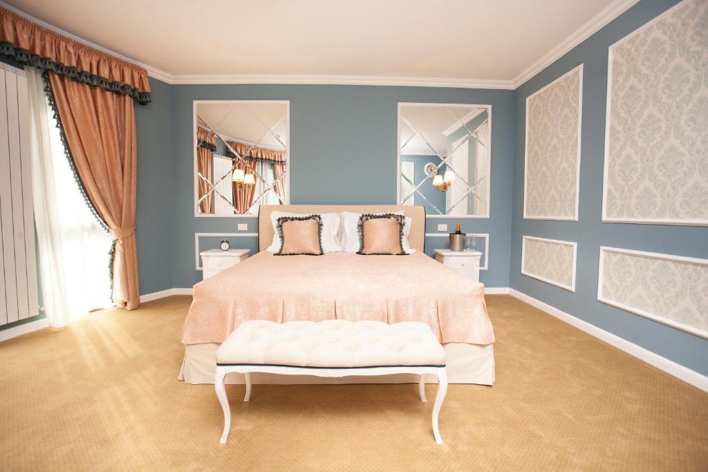 a bedroom with a bed and blue walls at Villa Boutique Lafayette in Bucharest
