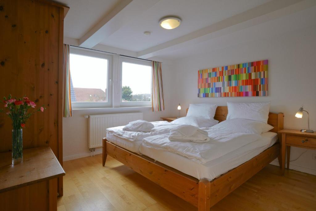 ヴィーク・アウフ・フェールにあるHaus Gud Hööb Whg 07のベッドルーム(白いシーツを使用した大型ベッド1台付)