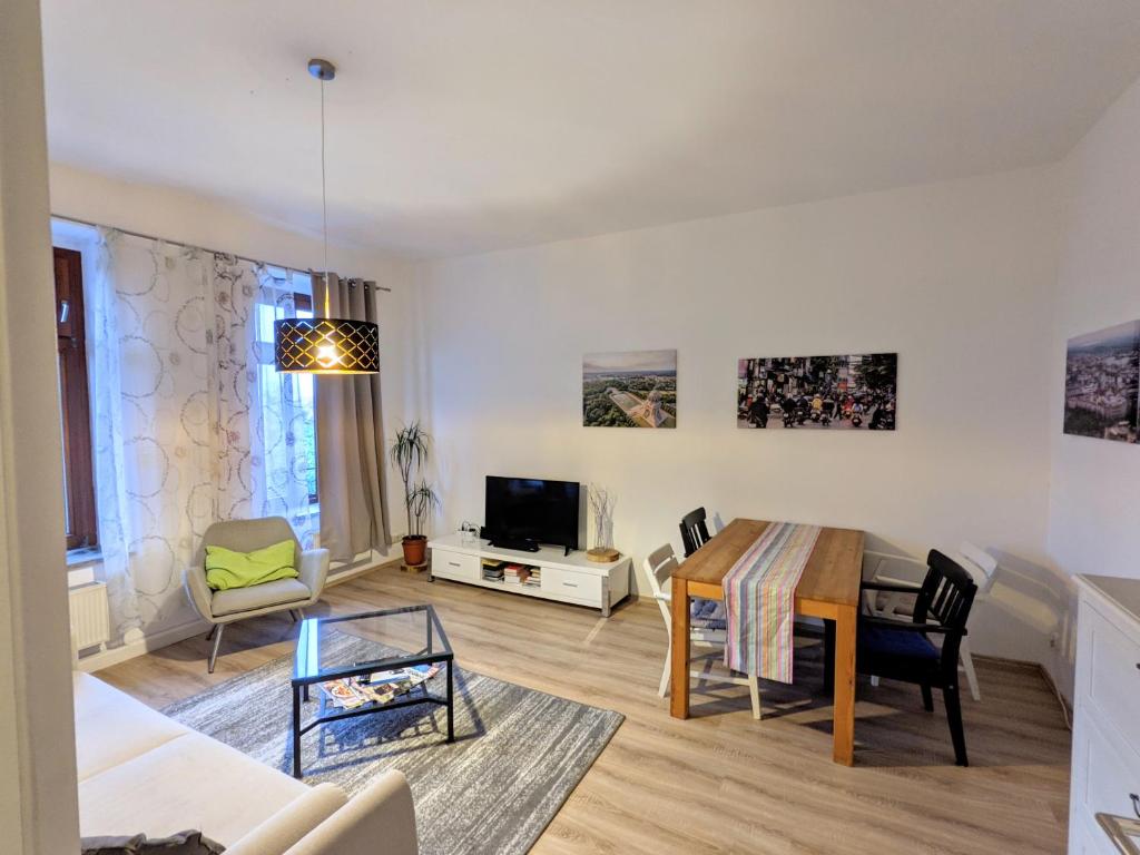 ein Wohnzimmer mit einem Tisch und einem Esszimmer in der Unterkunft City Apartment Leipzig in Leipzig