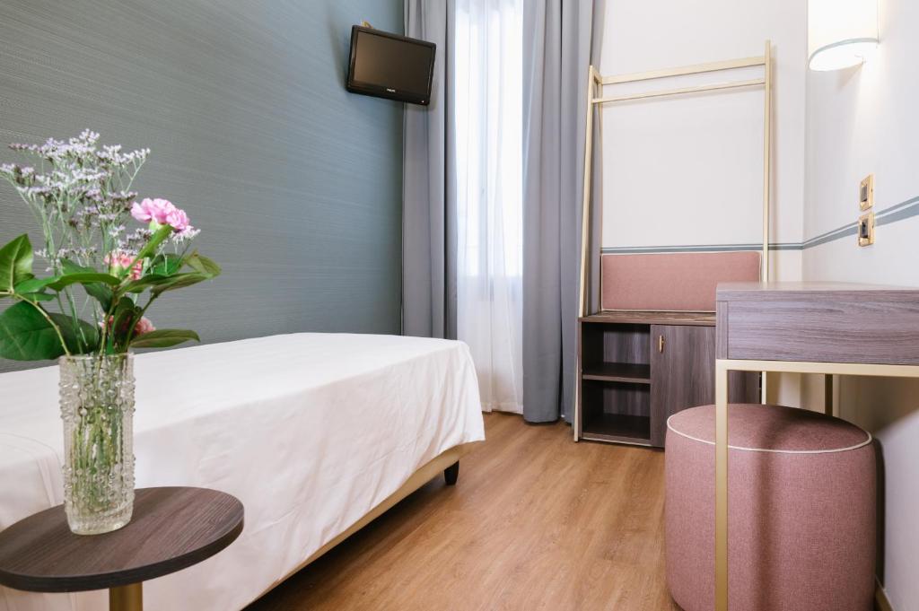 a room with a bed and a table with flowers on it at Hotel Do Pozzi in Venice