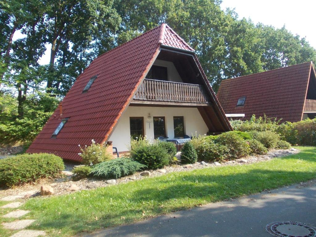 a small house with a red roof on a street at Finnhäuser am Vogelpark - Haus Luise in Marlow