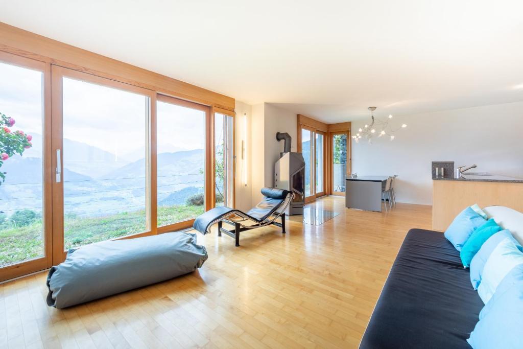 a large living room with large windows and a couch at Casa Mundaun in Falera