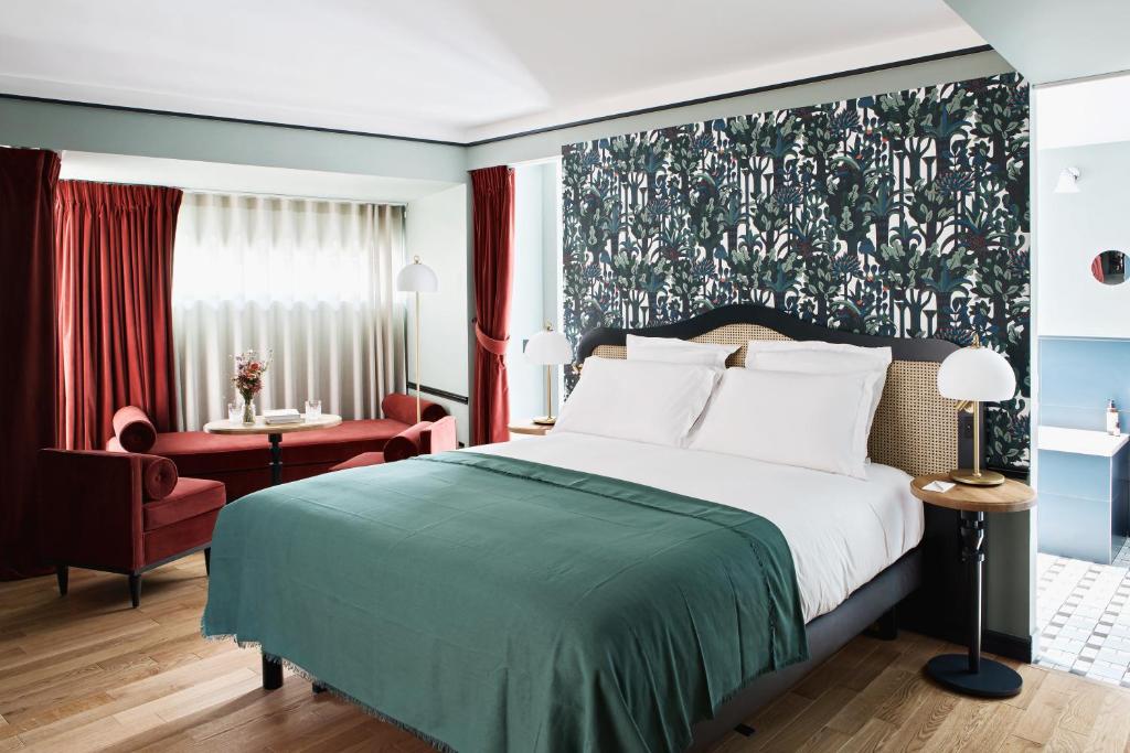 a bedroom with a large bed with a green blanket at Hôtel Botaniste in Paris