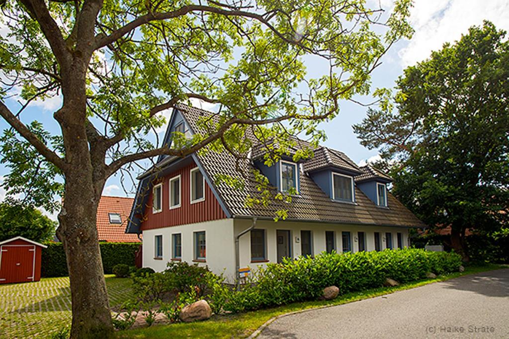 a red and white house with a gambrel roof at Ostseebrise FH 1 in Zingst