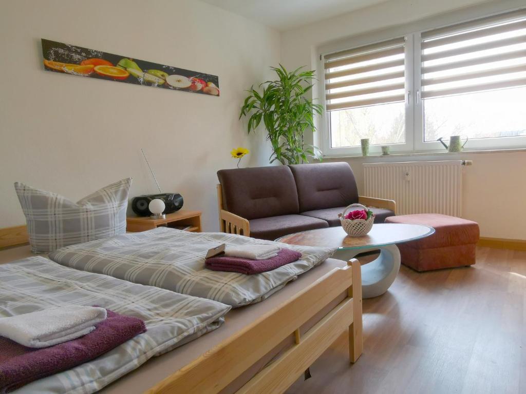 a bedroom with a bed and a couch and a table at Ferienwohnung Kaltschmidt in Radebeul