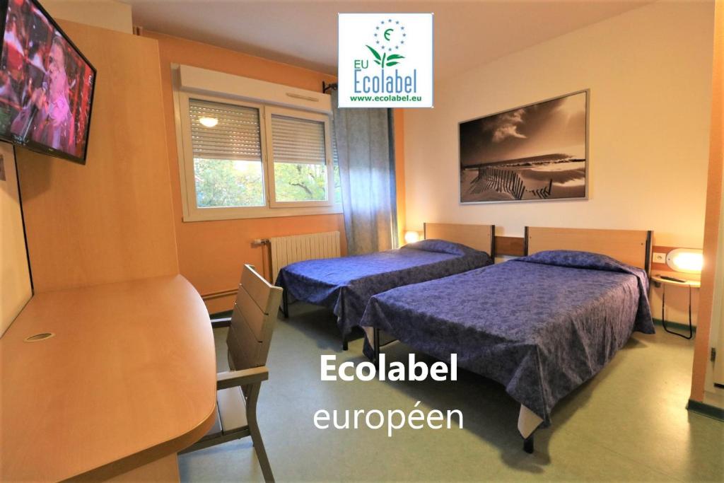 a hotel room with two beds and a tv at ETHIC ETAPES DIJON Accueil 24h24 et parking gratuit in Dijon