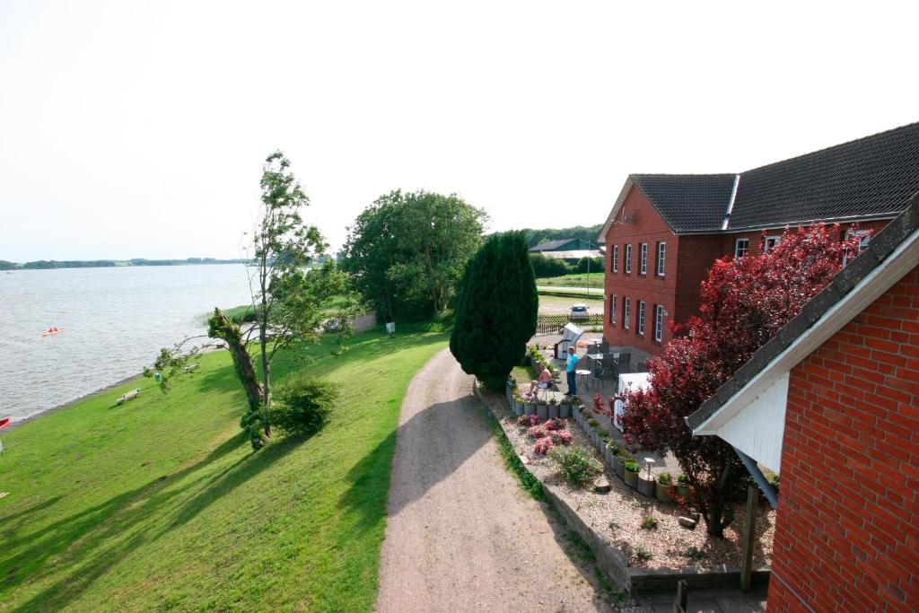 an aerial view of a house and a building next to the water at Schleiblick App 3 in Rabenkirchen-Faulück