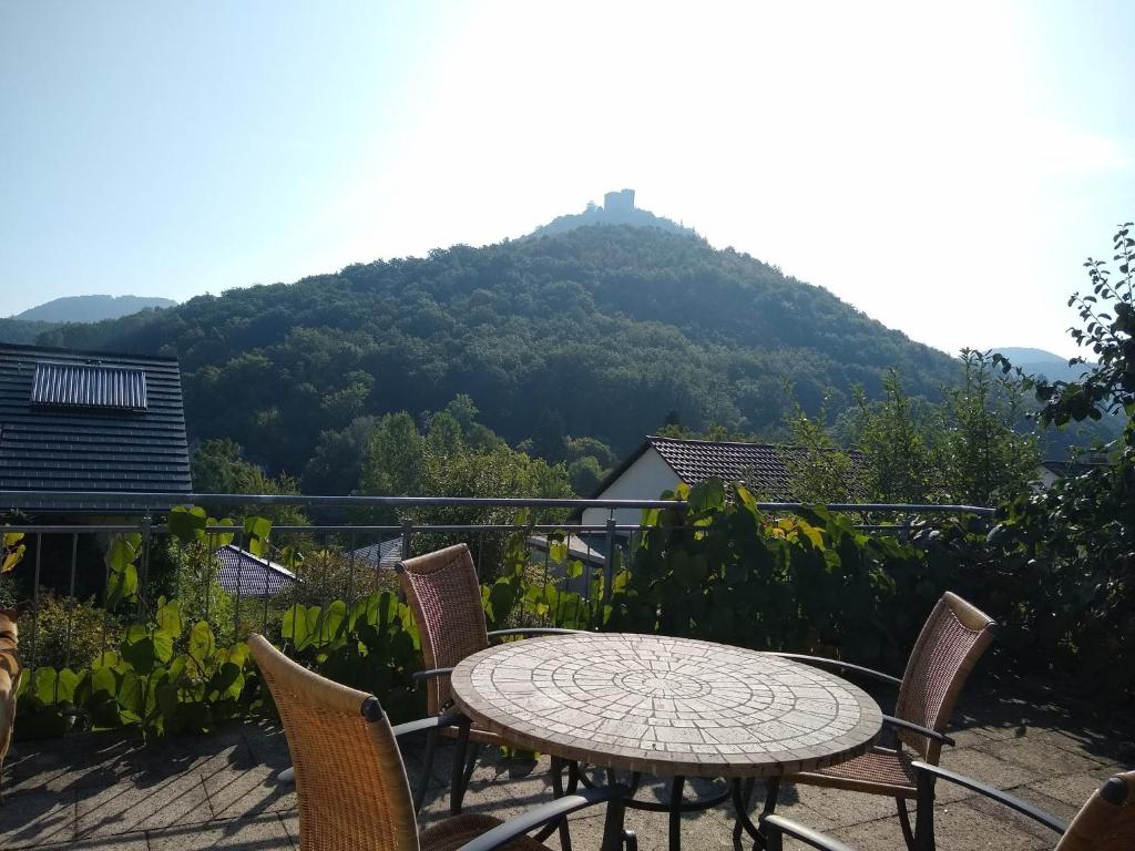 a table and chairs on a balcony with a mountain at Burgblick-Fewo Töpfer in Annweiler am Trifels