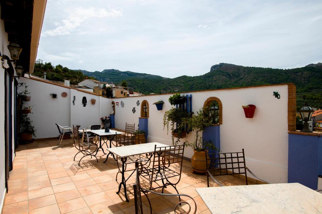 a patio with tables and chairs on a building at Hotel Casa Pilar Adults Only in Castell de Castells