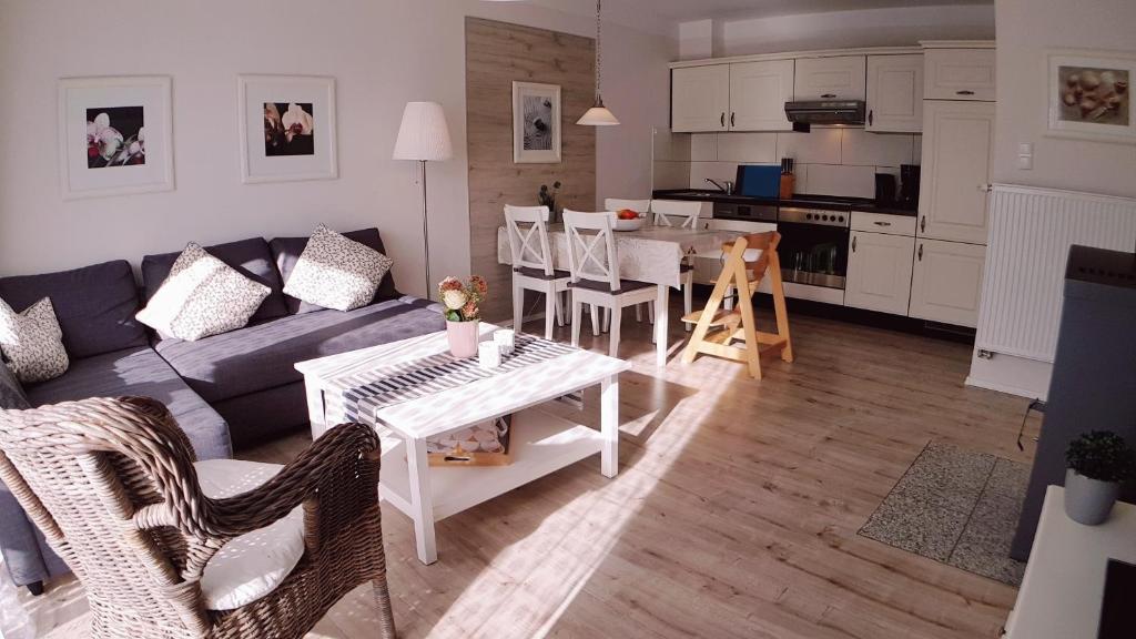 a living room with a couch and a table at Familienwohnung MANDO in Neue Tiefe Fehmarn