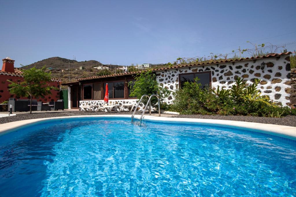 a swimming pool in front of a house at CASA RURAL LOS DRAGUITOS 2 in Santa Cruz de la Palma