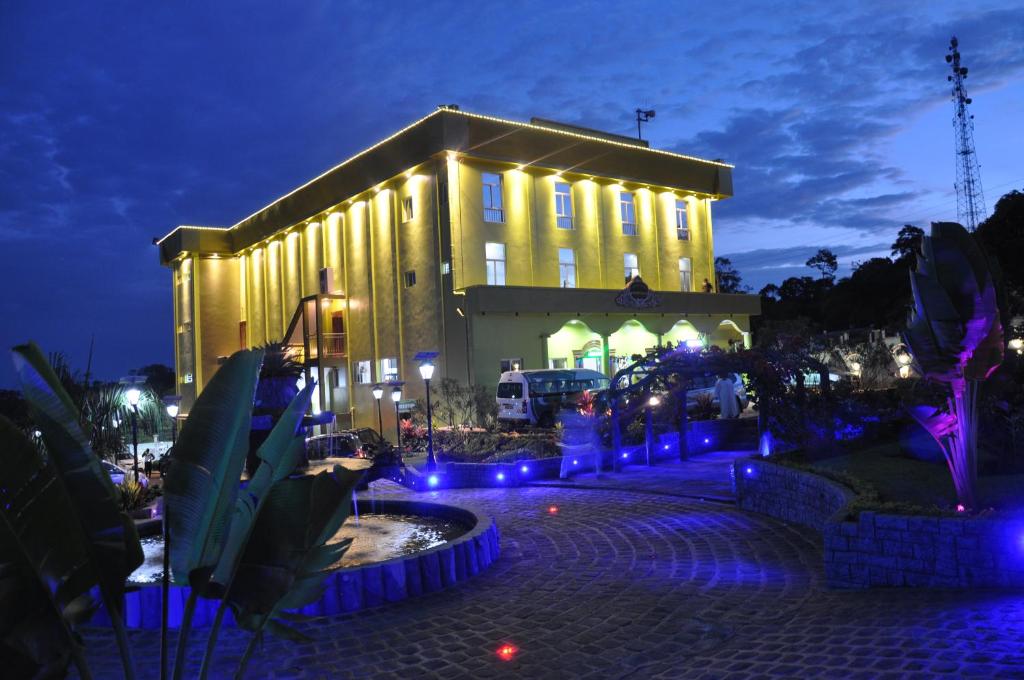un grand bâtiment avec des lumières bleues devant lui dans l'établissement United Hotel, à Mbankomo