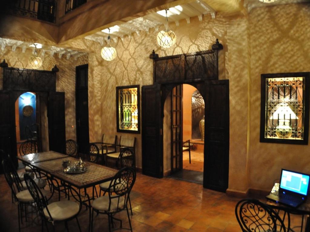 a dining room with tables and chairs in a building at Riad Marrakiss in Marrakech