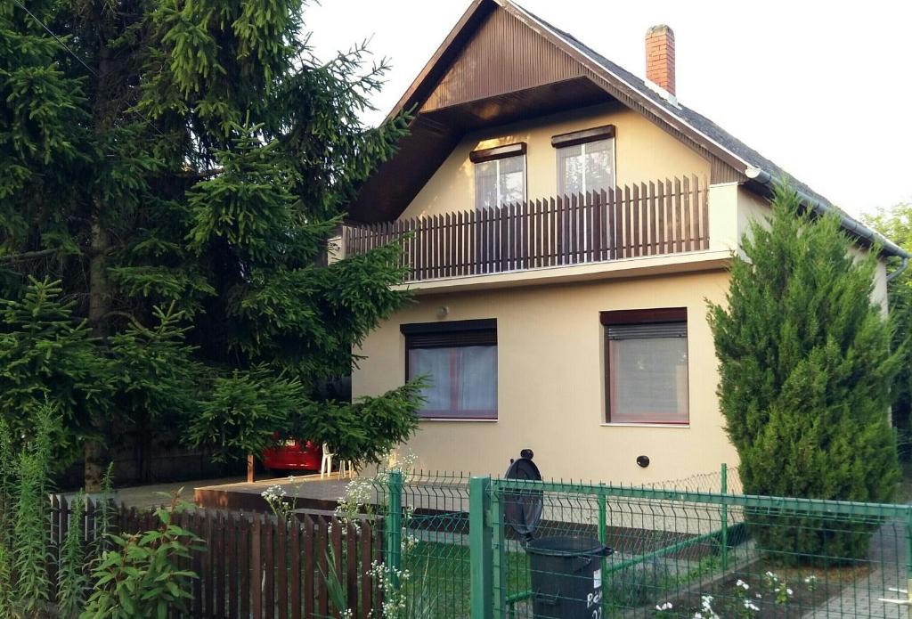 a house with a balcony on top of it at Szatmári Vendégház in Balatonlelle