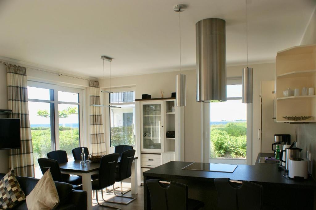 a kitchen and dining room with a table and chairs at Fehmarn-OstseeferienStrandresidenz Vogelflug 1438 in Fehmarnsund