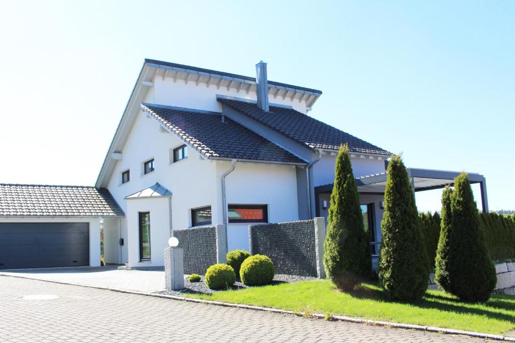 a white house with a black roof at Ferienhaus ALB-QUELLE in Gomadingen