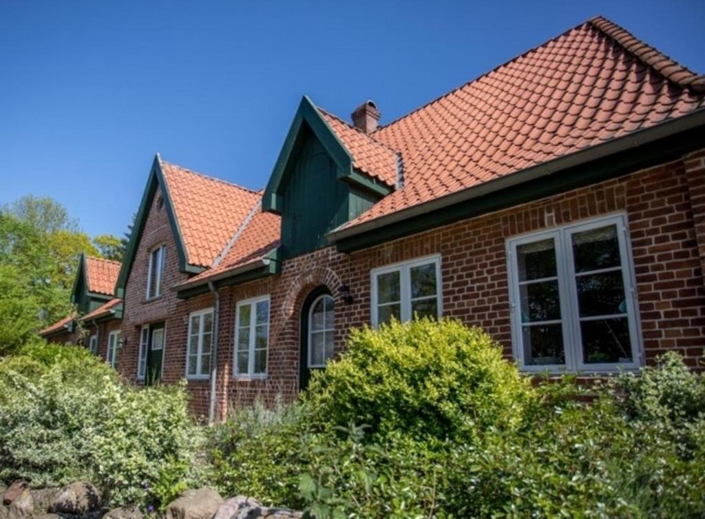 une maison en briques avec un toit rouge dans l'établissement Bellevue rechts, à Schashagen