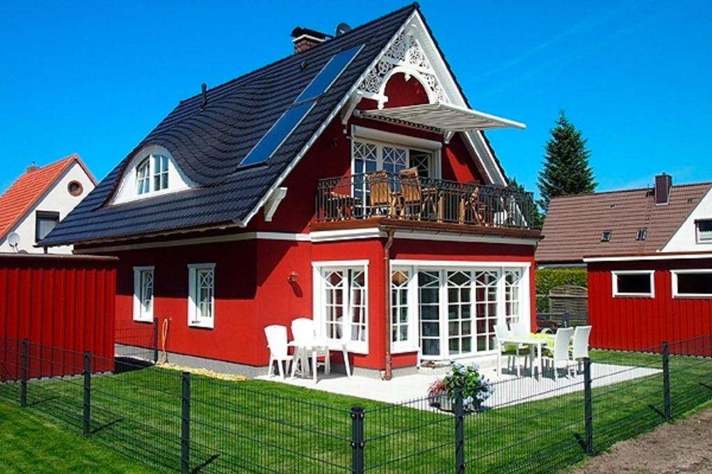 a red house with a balcony on top of it at Jolle in Zingst