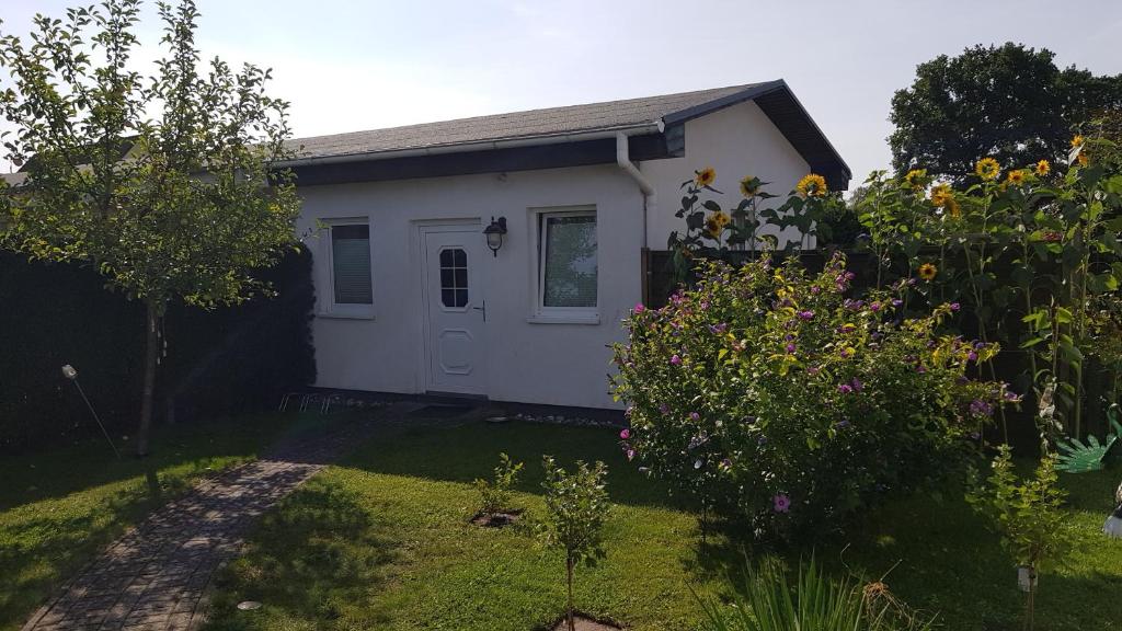 a small white house with a garden at Bungalow Mandy in Zinnowitz