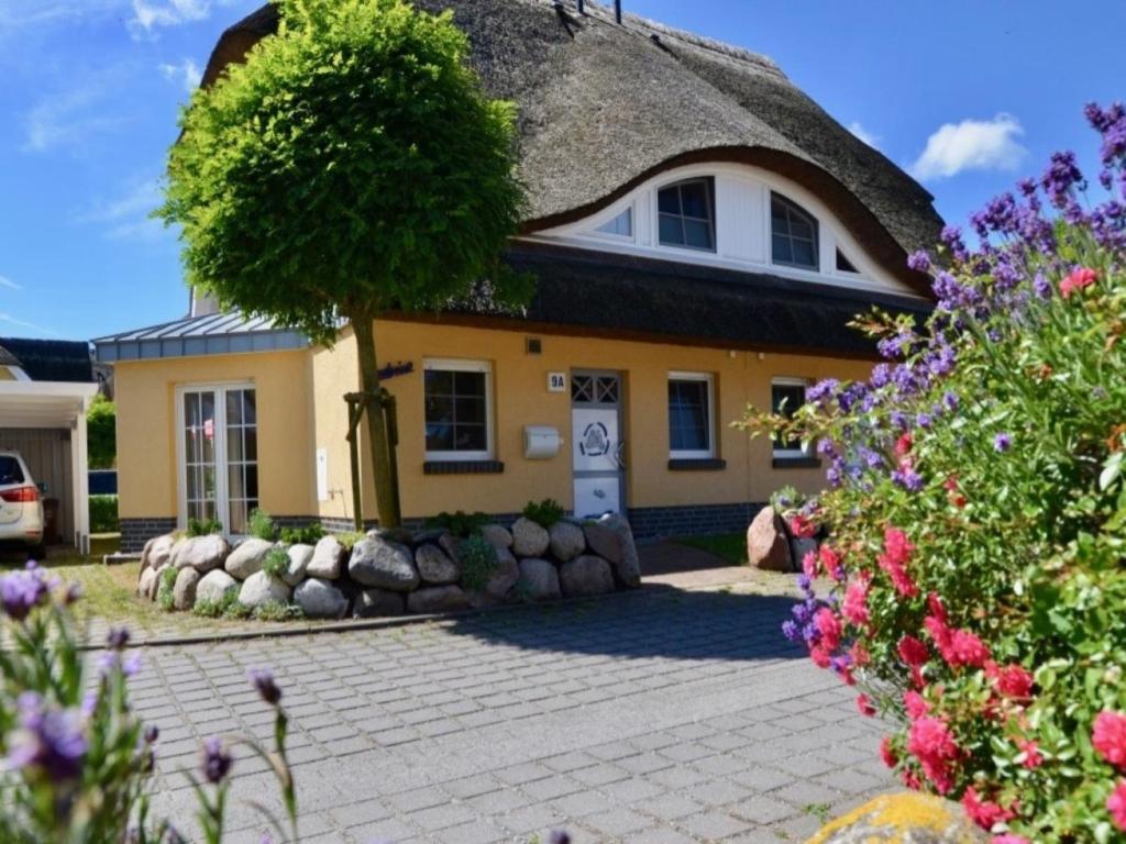 une maison jaune avec un toit de chaume dans l'établissement Ferienhaus Seebrise, à Zingst