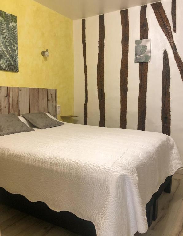 a bedroom with a bed with trees painted on the wall at Logis Hôtel Restaurant Métropole in Mirande