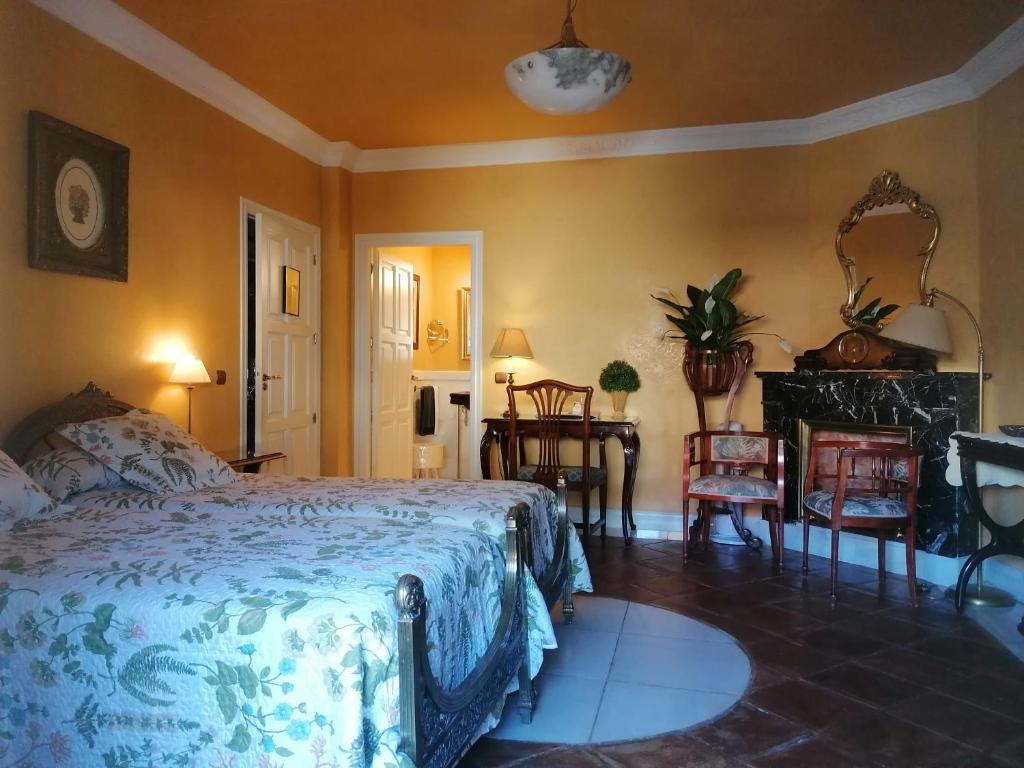 1 dormitorio con 1 cama, mesa y sillas en La Posada de Tamajon, en Tamajón