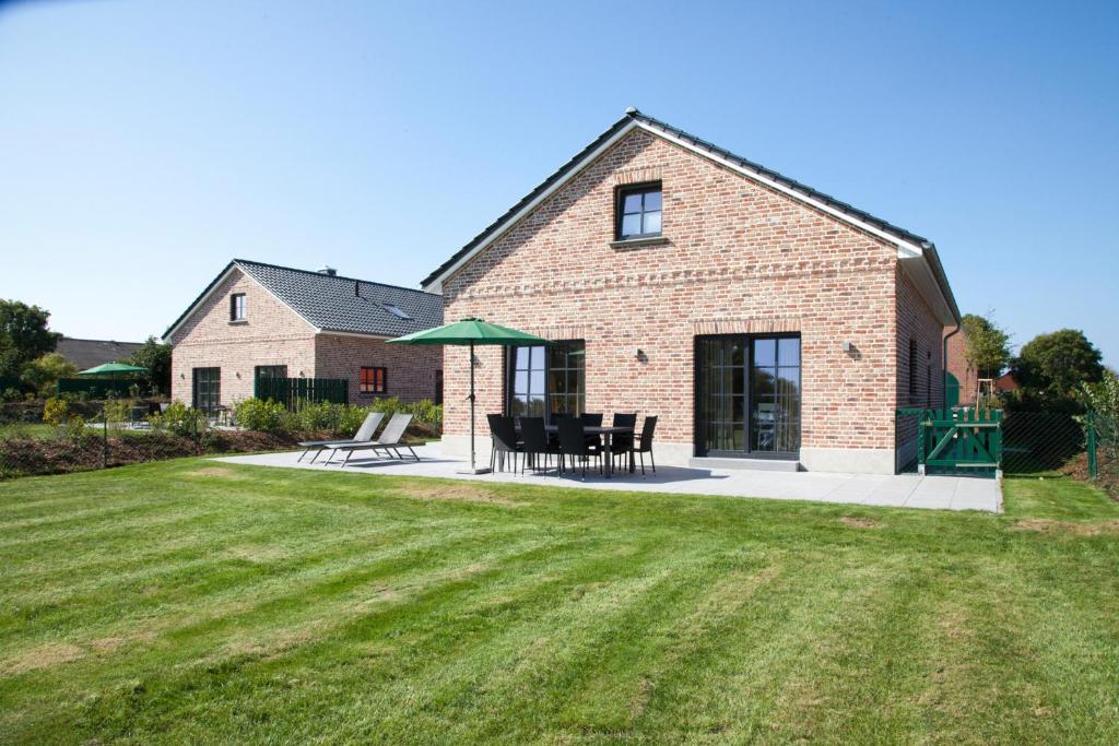 a brick house with a patio and a lawn at Ostseehaus 1 - 51526 in Westermarkelsdorf