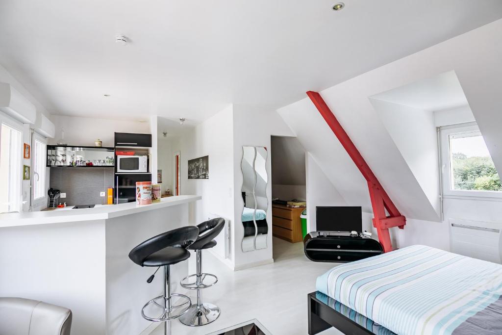 Cette chambre blanche comprend un lit et une chaise. dans l'établissement Le Galop, à Tréméreuc