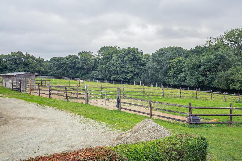 a wooden fence with a horse in a field at Le Galop in Tréméreuc