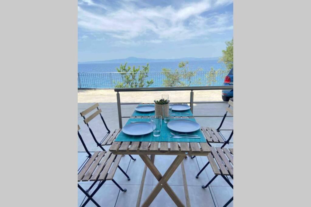 a table and chairs on a deck with a view of the ocean at DiFan Sea Homes A3 in Kalamata