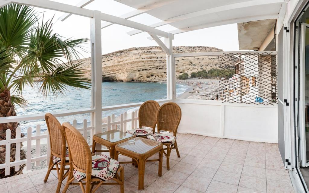 eine Terrasse mit Stühlen, einem Tisch und Meerblick in der Unterkunft Nautilus in Matala