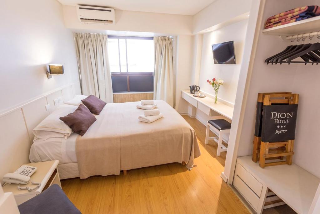Habitación pequeña con cama y escritorio. en Hotel Dion en Mar del Plata