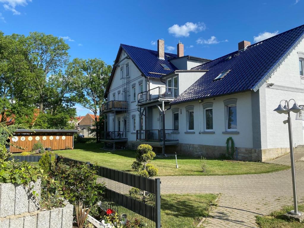 a white house with a black roof at Alte Molkerei FeWo 1 in Zilly