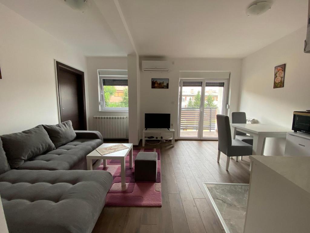 sala de estar con sofá y mesa en Dom apartmani en Kragujevac