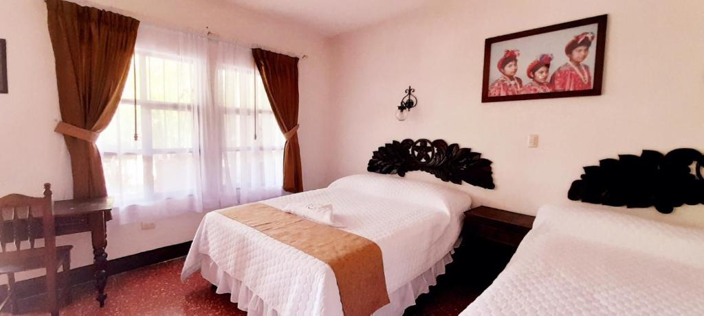 una camera d'albergo con due letti e una finestra di La Chacra de Joel Hotel a Huehuetenango