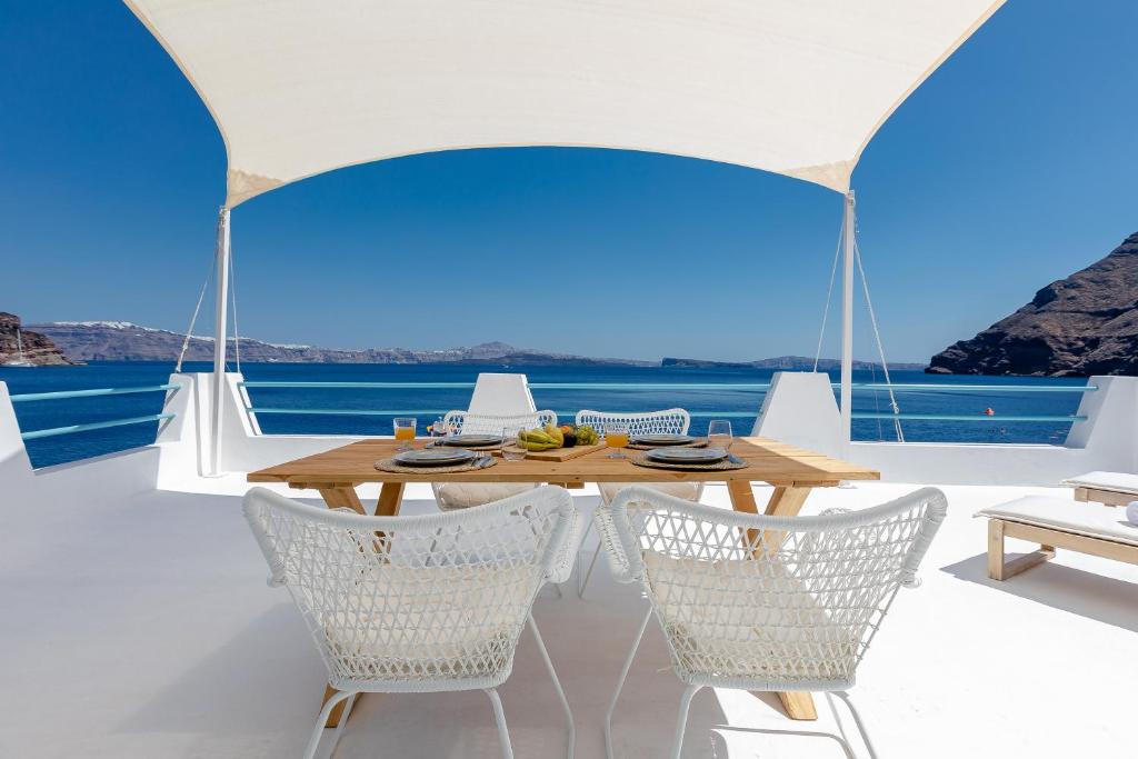 a table and chairs in a room with a view of the ocean at Petinos traditional house in Thirasia