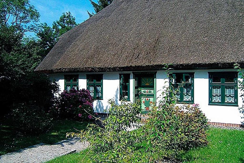 een klein wit huis met een rieten dak bij Ihrgistern, FW 3 in Zingst