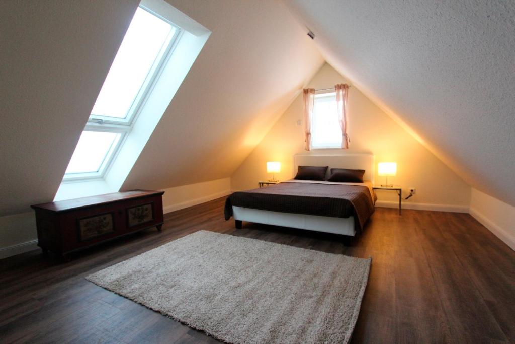Haby的住宿－Herrmannshof Haby App 4 Noor，阁楼卧室设有1张床和2扇窗户