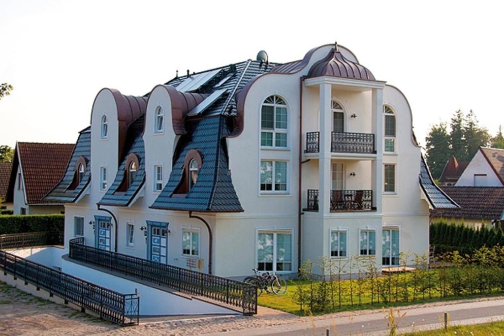 uma grande casa branca com um telhado de gambrel em Strandresidenz Deichgraf 8 em Zingst