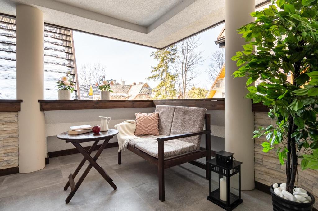 a balcony with a chair and a table at Prestige Apartament Przy Nosalu in Zakopane