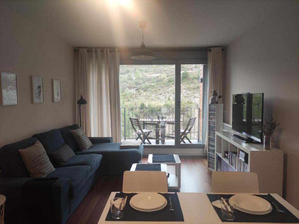 un soggiorno con un divano e un tavolo di Apartamento en Urb. Las Margas Golf (piscina) a Sabiñánigo