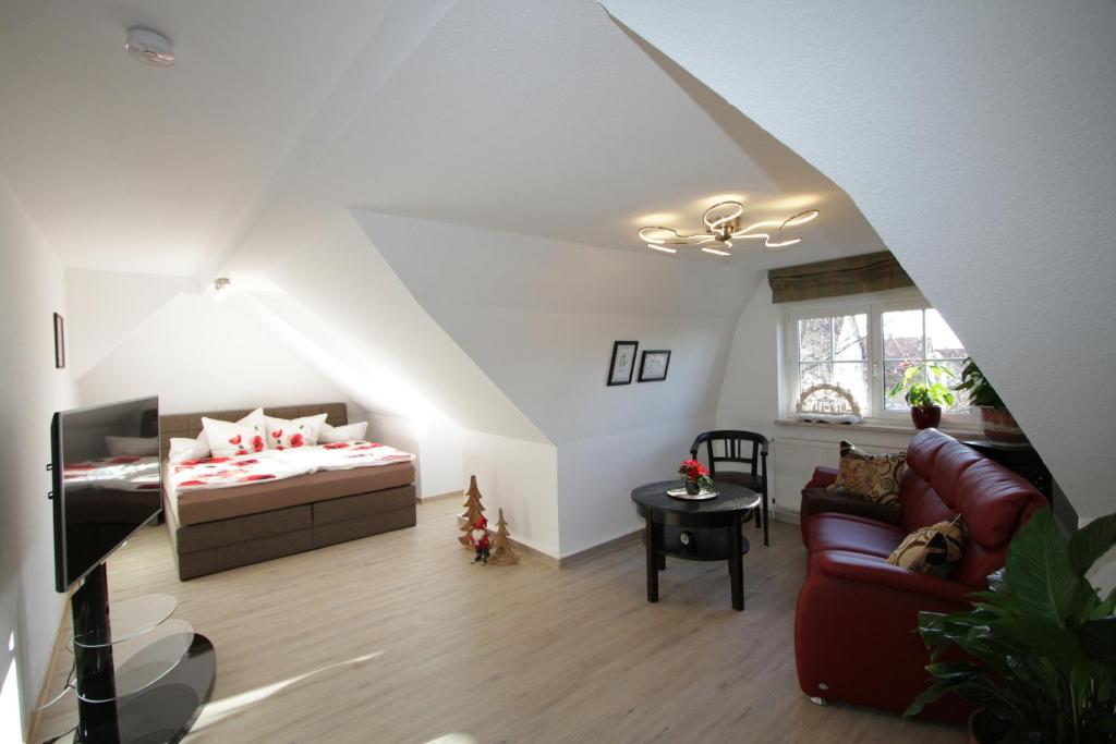 a attic room with a bed and a couch at Apartment am Kunsthaus Nordhausen in Nordhausen