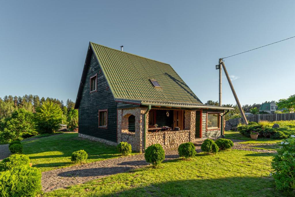 a small house with a green roof at Sodyba "Baltalaukis" in Didžiosios Kabiškės