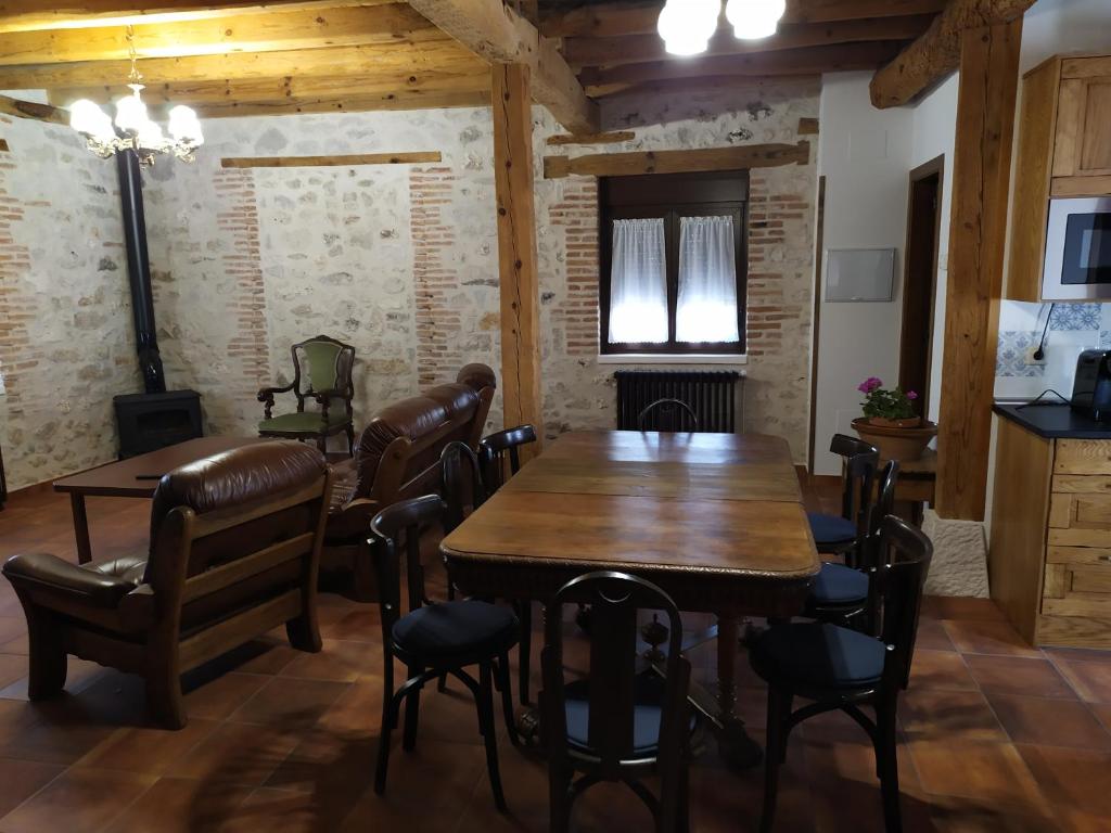 Sanchonuño的住宿－Casa Rural Las Cotarras，一间带木桌和椅子的用餐室